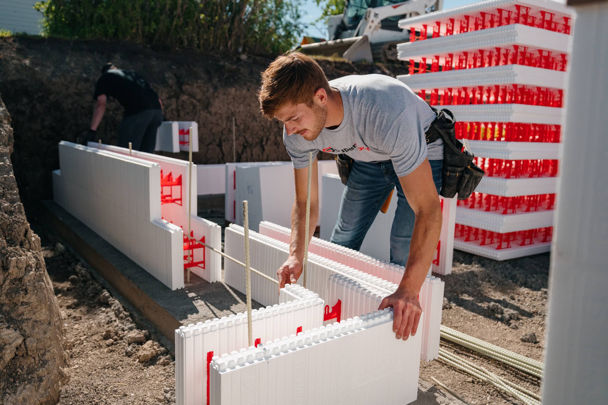 This image depicts a construction professional handling a SuperForm ICF block.