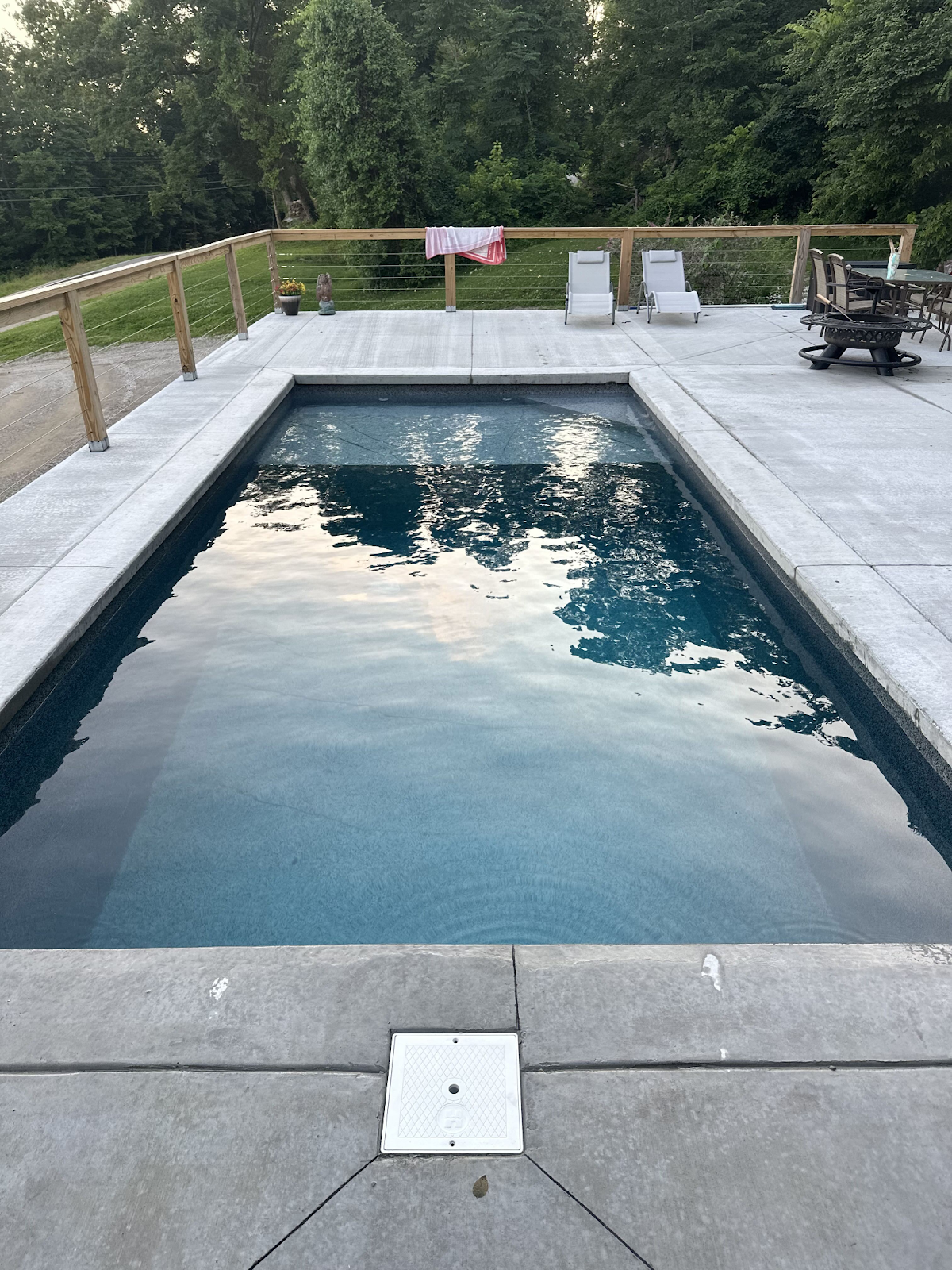 A beautiful, finished rectangular ICF pool is surrounded by concrete decking.